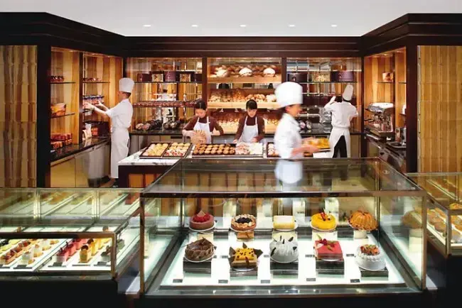 Usaha Cake dan Bakery Interior usaha bakery dengan etalase kue dan staf produksi