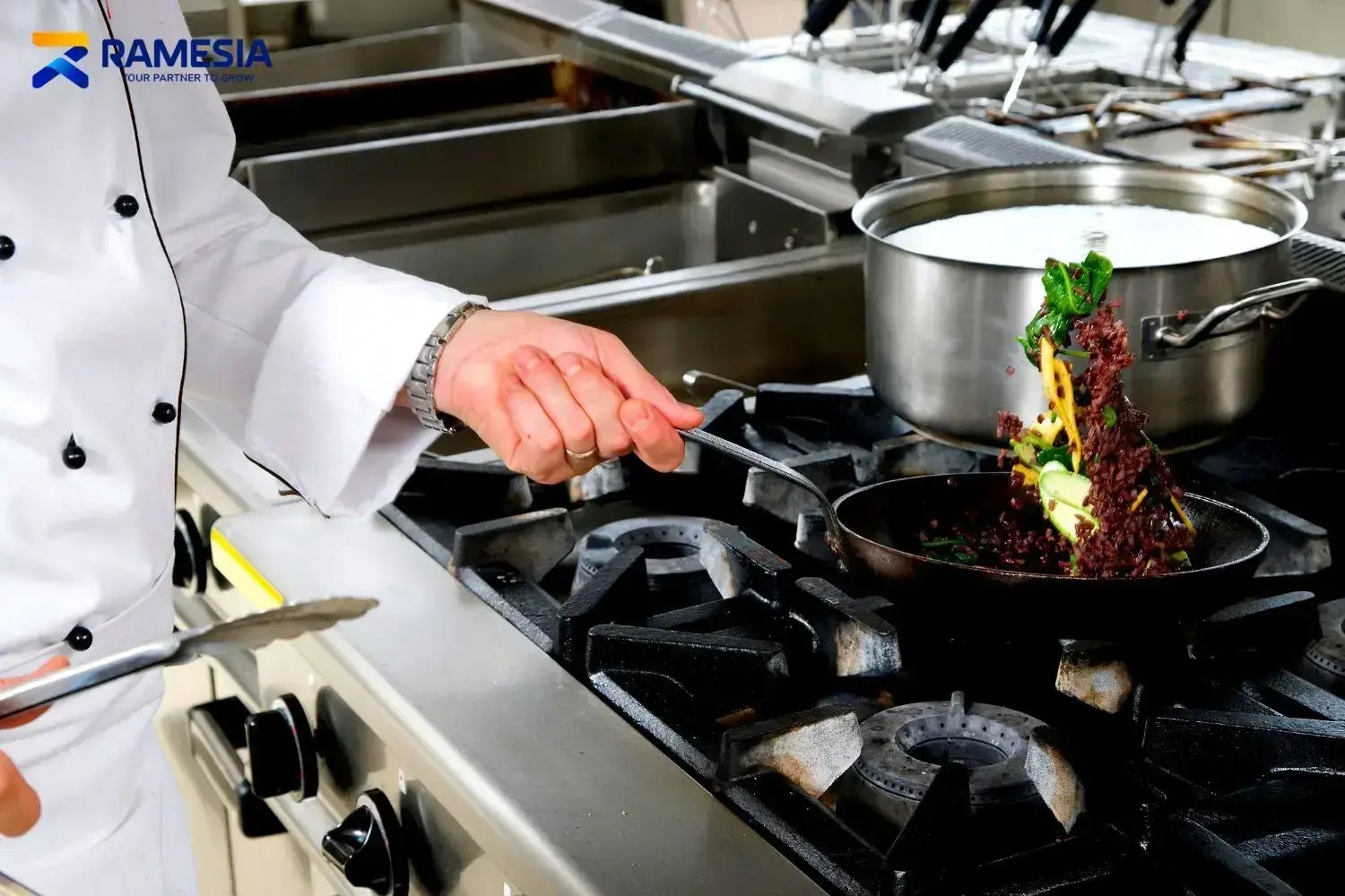 Chef restoran menggunakan kompor profesional